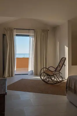 a room with a chair in front of a window at Almarìa - Le case del Castello - San Nicola L'Arena - Trabia in Trabia