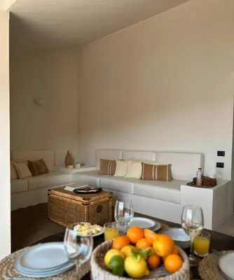 a living room with a table with fruits and wine glasses at Almarìa - Le case del Castello - San Nicola L'Arena - Trabia in Trabia