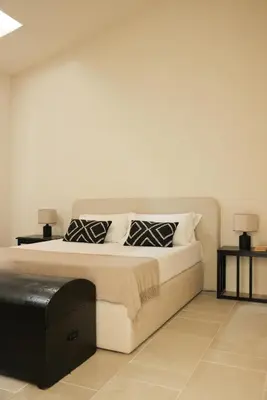 a bedroom with a large bed with two tables at Almarìa - Le case del Castello - San Nicola L'Arena - Trabia in Trabia