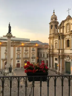 a view of a building with a statue and flowers at Dimora San Domenico in Palermo