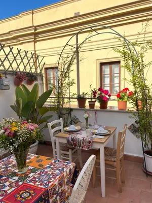 a patio with tables and chairs and potted plants at Dimora San Domenico in Palermo