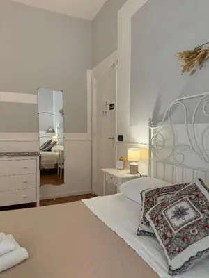 a white bedroom with a bed and a mirror at Dimora San Domenico in Palermo