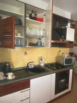 a kitchen with a sink and a stove and cabinets at Villetta SCHIRÒ - BAGNASCO in Campofelice di Roccella