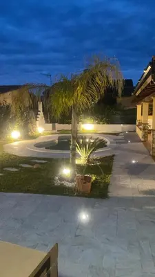 a courtyard with a palm tree and lights at night at Villetta SCHIRÒ - BAGNASCO in Campofelice di Roccella