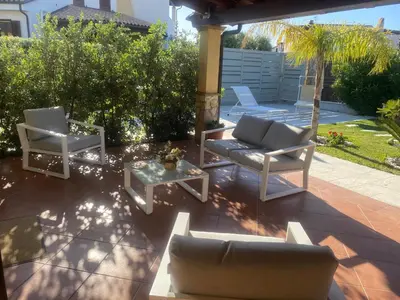 a patio with two chairs and a couch and a table at Villetta SCHIRÒ - BAGNASCO in Campofelice di Roccella