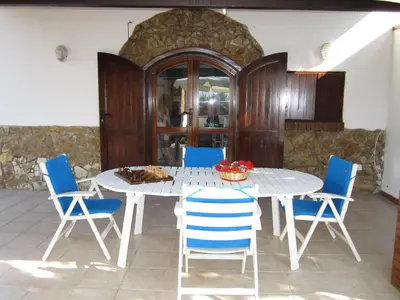 a dining room with a white table and blue chairs at Casa Vacanze Daisy in Trappeto