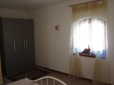 a bedroom with a window and a bed and a curtain at Casa Vacanze Daisy in Trappeto