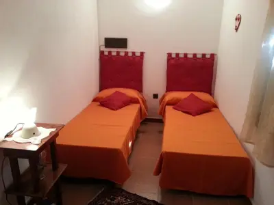 two beds in a room with red headboards at Casa Vacanze Daisy in Trappeto