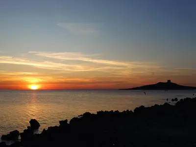 a sunset over a body of water with the sun setting at Darling in Capaci