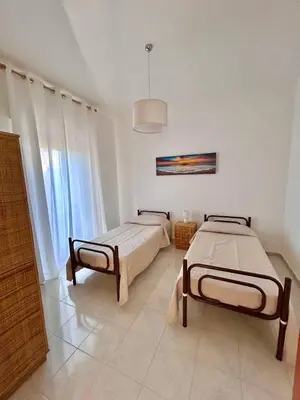 a bedroom with two beds and a large window at Villa Gargaf in Altavilla Milicia