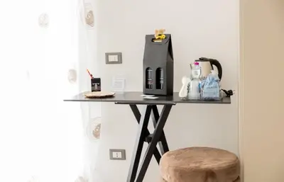 a desk with a computer on a table with a stool at B&B Terre del cretto in Nuova Gibellina