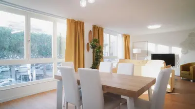 a dining room with a table and white chairs at Encanto Apartment in Palermo