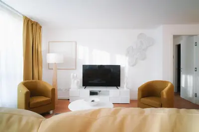 a living room with a television and two chairs at Encanto Apartment in Palermo