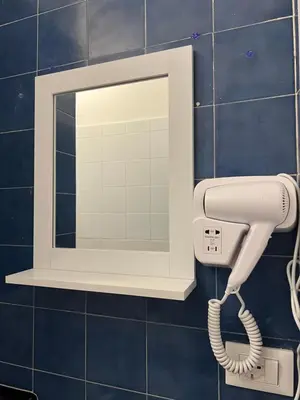 a hair dryer on a wall with a mirror at Home Sampolo in Palermo