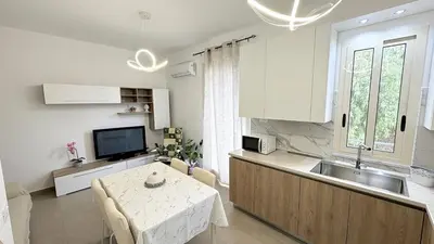 a kitchen with a table and a kitchen with a sink at Appartamento La Duchessa in Campofelice di Roccella