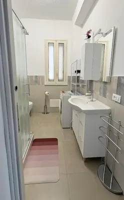 a white bathroom with a sink and a shower at Appartamento La Duchessa in Campofelice di Roccella