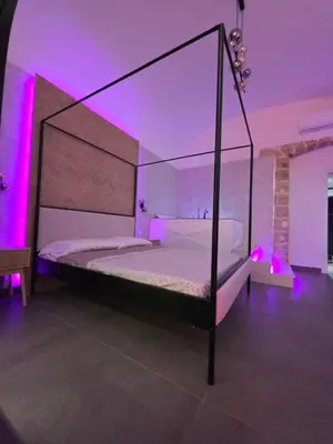 a bedroom with a canopy bed with purple lights at Thaleia Suite & Spa in Palermo