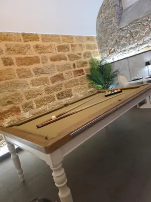 a ping pong table in front of a brick wall at Thaleia Suite & Spa in Palermo