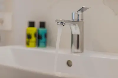 a sink with a faucet and two bottles of soap at NAHIA Collection Villa in Campofelice di Roccella