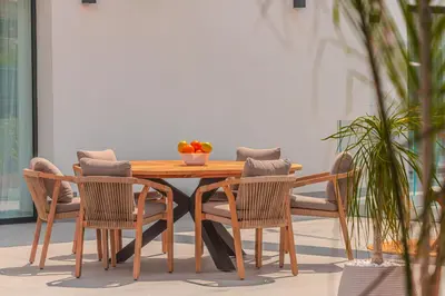a wooden table and chairs with a bowl of fruit on it at NAHIA Collection Villa in Campofelice di Roccella