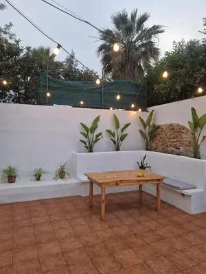 a patio with a wooden table and a white wall at Mammì in Balestrate