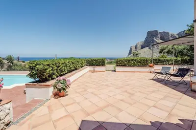 a patio and swimming pool with a view of the ocean at Pool & Panoramic Villa - 9 mins city center in Palermo
