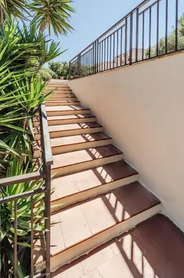 a staircase with wooden steps next to a wall at Pool & Panoramic Villa - 9 mins city center in Palermo