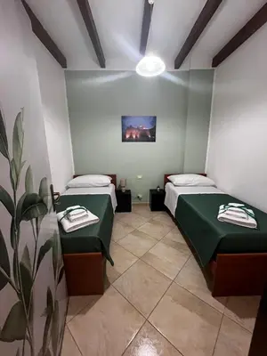 a room with two beds and a painting on the wall at Dimora del Moro in Castellammare del Golfo