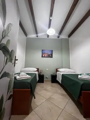 a room with two beds and a painting on the wall at Dimora del Moro in Castellammare del Golfo