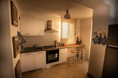 a small kitchen with white cabinets and a sink at Casa Alagna - La Casetta al Mare con Idromassaggio in Palermo