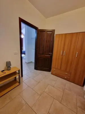 a living room with wooden cabinets and a tiled floor at Casa Vacanze Soleado house Trabia PA, Sicily in Mandra Capreria