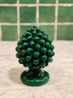 a green glass vase with a bunch of green grapes at Mia Domus in Palermo