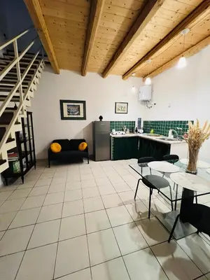 a living room with a table and chairs and a kitchen at Mia Domus in Palermo