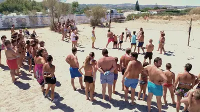 a group of children playing in the sand at the beach at Campeggio Praia Mare in Campofelice di Roccella