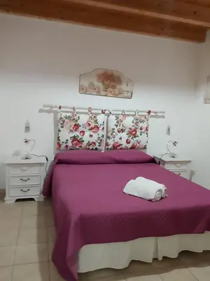 a bedroom with a purple bed with two night stands at La Casetta Di Liù in Villagrazia