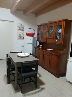 a kitchen with a table and chairs and a cabinet at La Casetta Di Liù in Villagrazia