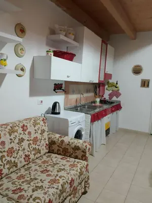 a kitchen with a couch and a stove top oven at La Casetta Di Liù in Villagrazia
