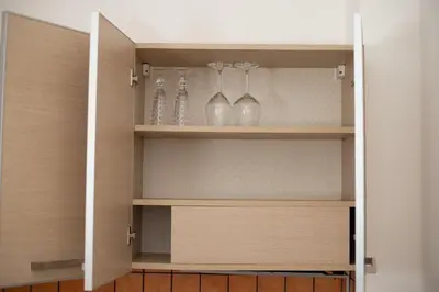 a cupboard with glasses and vases sitting in it at Re Tancredi Apartment in Palermo