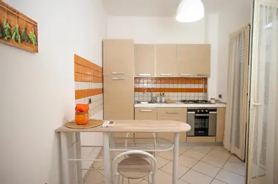 a kitchen with a table and some chairs in it at Re Tancredi Apartment in Palermo