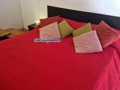 a red bed with red sheets and pillows on it at House Vintage Charme by Holiday World in Palermo