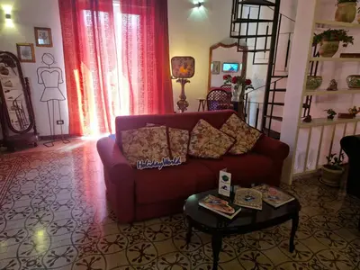 a living room with a red couch and a table at House Vintage Charme by Holiday World in Palermo