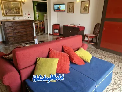 a living room with a red couch with colorful pillows at House Vintage Charme by Holiday World in Palermo