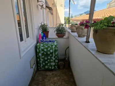 a balcony with potted plants and a bag next to a window at House Vintage Charme by Holiday World in Palermo