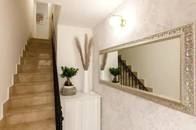 a mirror on a wall next to a staircase at IG Holiday in Cinisi