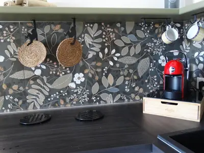 a kitchen with a wall with a floral wallpaper at La Maschera di Giano, case vacanza vista mare in Palermo