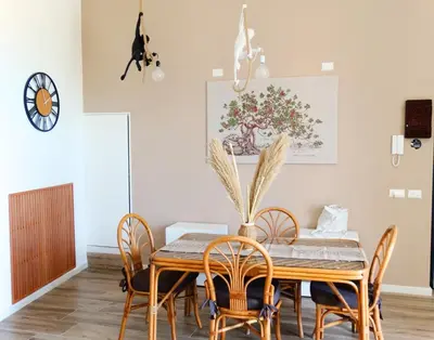 a dining room with a wooden table and chairs at La Maschera di Giano, case vacanza vista mare in Palermo
