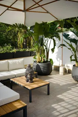 a patio with a couch and a table and plants at Villa Finch Mondello in Palermo
