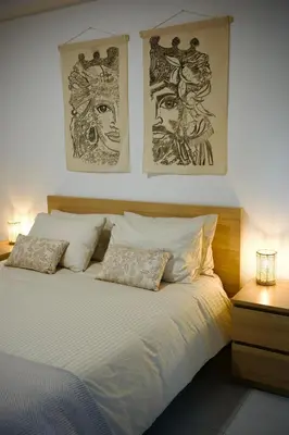 a bedroom with a bed with two pictures on the wall at Villa Finch Mondello in Palermo