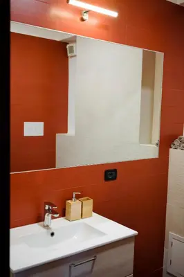 a bathroom with a sink and a large mirror at Villa Finch Mondello in Palermo