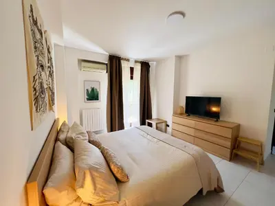 a bedroom with a large bed and a television at Villa Finch Mondello in Palermo